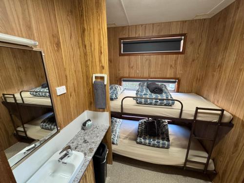 a room with two bunk beds and a sink at Acacia Caravan Park & Holiday Units in Ararat
