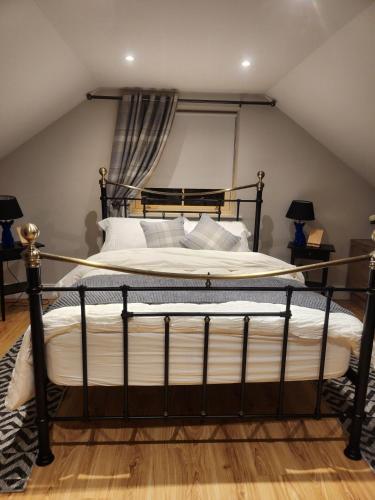 a bedroom with a black bed with white pillows at Ravensdale Retreat Dundalk in Dundalk