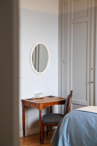 a table and a chair with a mirror on a wall at Château Haute Roche in Oudon