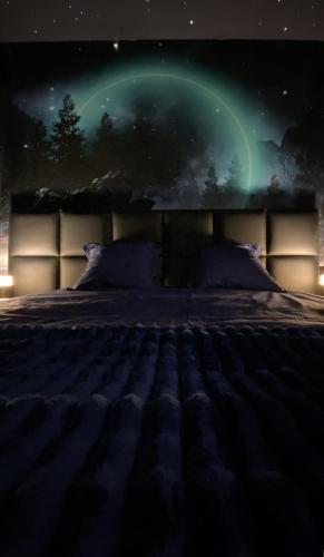 - une chambre dotée d'un lit et d'une lumière verte du nord dans l'établissement 21 lunes - séjour magique & jeu immersif pour deux, à Roanne