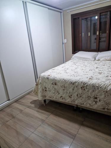 une chambre avec un lit et une grande fenêtre dans l'établissement Casa aconchego!, à Gramado