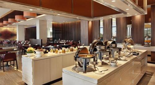 a restaurant with a buffet line with pots and pans at Mercure Karawang in Karawang