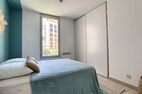 a bedroom with a bed and a window at Centre, lumineux appartement T3 6 Pers Terrasse wifi pkg clim in Antibes