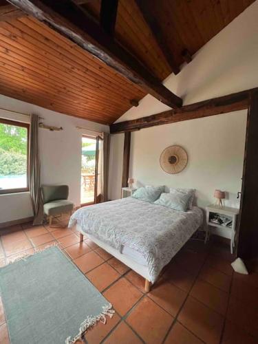 une chambre avec un lit et une chaise dans une pièce dans l'établissement Landaise 12 couchages - piscine tennis boulodrome privés - proche lacs & océan, à Ychoux