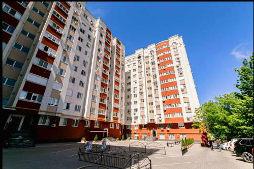 two tall apartment buildings with benches in front of them at BUIUCANI APARTAMENTS & TAXI AiRPORT in Durleşti