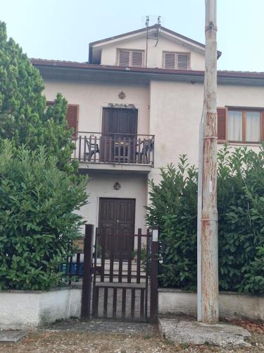 a house with a black gate and a balcony at B&B A Casa di Anna in Fassinoro
