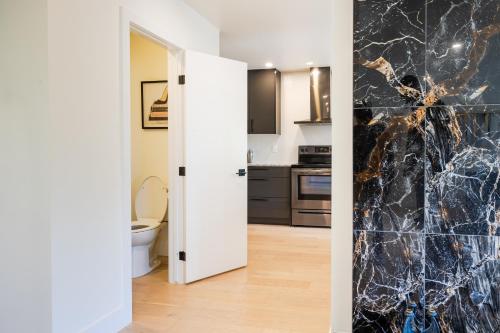 ロンドンにある5 Bedroom Luxury Retreat with Hot Tub and Sauna, Prime Location and More!の黒と白の大理石の壁のキッチン