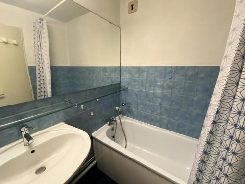 une salle de bain avec un lavabo, une baignoire et un miroir dans l'établissement Résidence Albaron - Studio pratique et bien situé MAE-4231, à Bessans