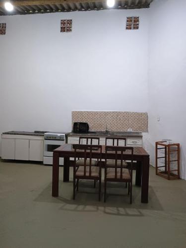 a kitchen with a table and chairs and a stove at Sítio das Palmeiras in Itapecerica da Serra