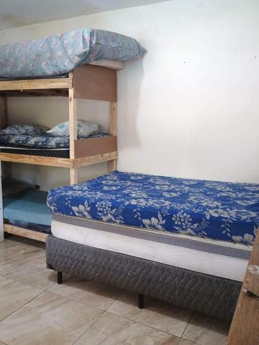 a bedroom with two bunk beds with blue sheets at Sítio das Palmeiras in Itapecerica da Serra