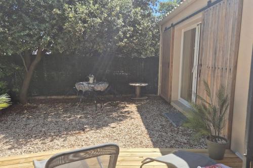 une cour avec une table, des chaises et une clôture dans l'établissement Studio en vaucluse , campagne jacuzzi près d Orange, à Mondragon