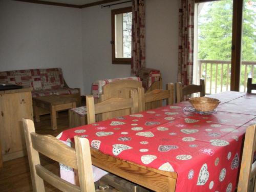 une salle à manger avec une table avec une nappe rouge dans l'établissement Résidence Le Clos Vanoise - 4 Pièces pour 8 Personnes MAE-4321, à Bessans