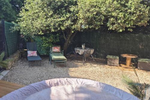 une cour avec des chaises, une table et un arbre dans l'établissement Studio en vaucluse , campagne jacuzzi près d Orange, à Mondragon