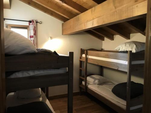 deux lits superposés dans une petite pièce avec dans l'établissement Résidence Le Clos Vanoise - 4 Pièces pour 8 Personnes MAE-4321, à Bessans