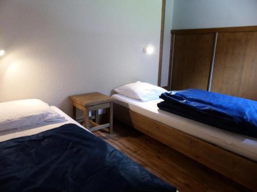 - 2 lits dans une petite chambre avec une table dans l'établissement Résidence Le Clos Vanoise - 3 Pièces pour 8 Personnes MAE-4331, à Bessans