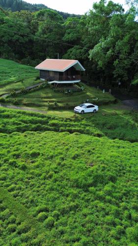a car parked in front of a house in a field at Cabaña Montaña de Sueños in Quesada