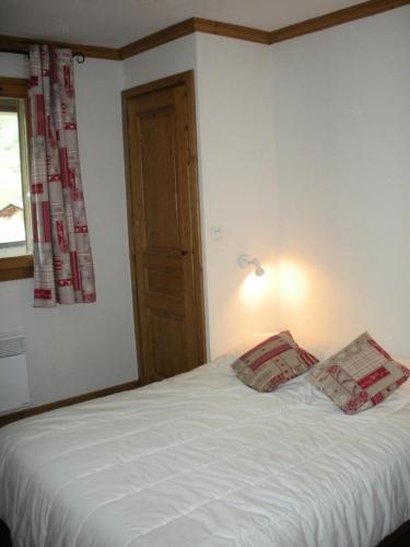 une chambre avec un lit avec deux oreillers dessus dans l'établissement Résidence Le Clos Vanoise - 2 Pièces pour 6 Personnes MAE-4411, à Bessans
