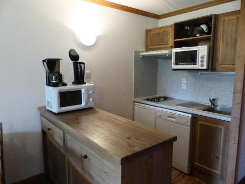 une cuisine avec un four micro-ondes au-dessus d'un comptoir dans l'établissement Résidence Le Clos Vanoise - 2 Pièces pour 6 Personnes MAE-4431, à Bessans