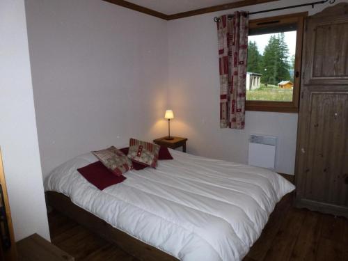 une chambre avec un grand lit blanc avec une fenêtre dans l'établissement Résidence Le Clos Vanoise - 2 Pièces pour 6 Personnes MAE-4431, à Bessans