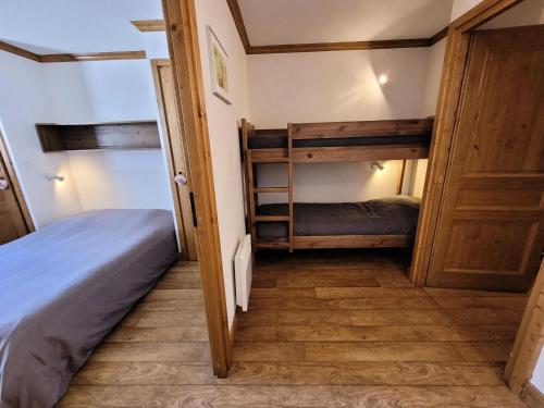 Cette chambre comprend 2 lits superposés et une porte. dans l'établissement Résidence Le Clos Vanoise - 2 Pièces pour 6 Personnes MAE-4441, à Bessans