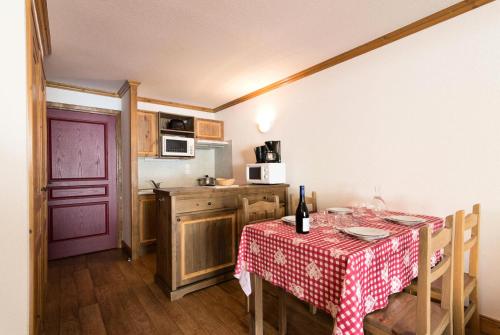 une cuisine avec une table avec une nappe rouge et blanche dans l'établissement Résidence Le Clos Vanoise - 2 Pièces pour 6 Personnes MAE-4441, à Bessans