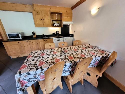 une pièce avec une table et des chaises et une cuisine dans l'établissement Résidence Le Criterium - Appartement 6 personnes spacieux MAE-4381, à Lanslebourg-Mont-Cenis