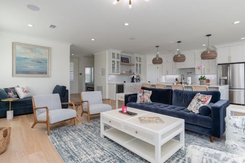 a living room with blue couches and a kitchen at LUXE Azul Oasis PRIVATE Pool Views Walk to Beach Pets Sleeps 14 in Orange Beach