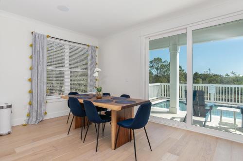 a dining room with a table and chairs and a balcony at LUXE Azul Oasis PRIVATE Pool Views Walk to Beach Pets Sleeps 14 in Orange Beach