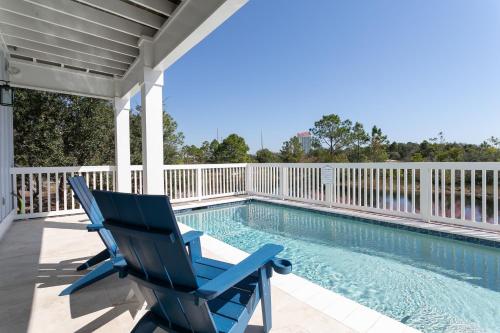 a blue chair sitting on a porch next to a swimming pool at LUXE Azul Oasis PRIVATE Pool Views Walk to Beach Pets Sleeps 14 in Orange Beach