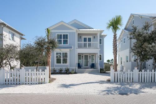 a white picket fence in front of a white house at LUXE Azul Oasis PRIVATE Pool Views Walk to Beach Pets Sleeps 14 in Orange Beach