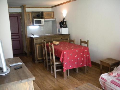 une petite cuisine avec une table et un chiffon rouge dans l'établissement Résidence Le Clos Vanoise - 2 Pièces pour 6 Personnes MAE-4521, à Bessans
