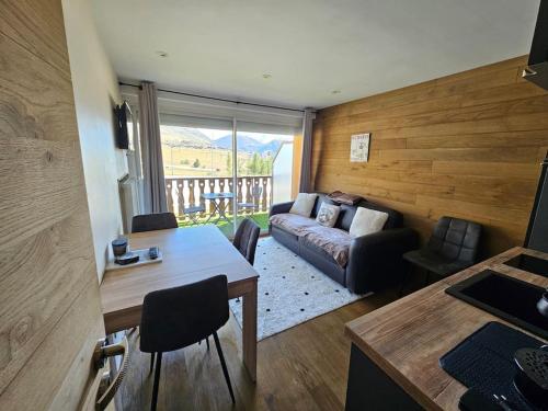 un salon avec un canapé et une table dans l'établissement Appart ski aux pieds Alpe d'Huez, à Huez