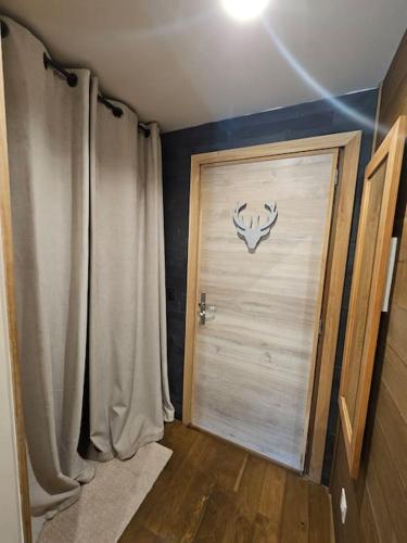 une chambre dotée d'une porte avec une tête de cerf sur le mur dans l'établissement Appart ski aux pieds Alpe d'Huez, à Huez