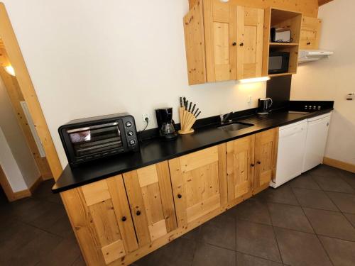 une cuisine avec un comptoir avec un micro-ondes dans l'établissement Résidence Le Criterium - Appartement 6 personnes spacieux MAE-4451, à Lanslebourg-Mont-Cenis