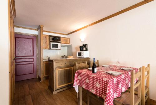une cuisine avec une table avec une nappe rouge et blanche dans l'établissement Résidence Le Clos Vanoise - 2 Pièces pour 6 Personnes MAE-4471, à Bessans