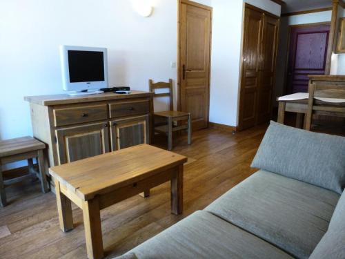 - un salon avec un canapé et une télévision sur un bureau dans l'établissement Résidence Le Clos Vanoise - 2 Pièces pour 6 Personnes MAE-4471, à Bessans