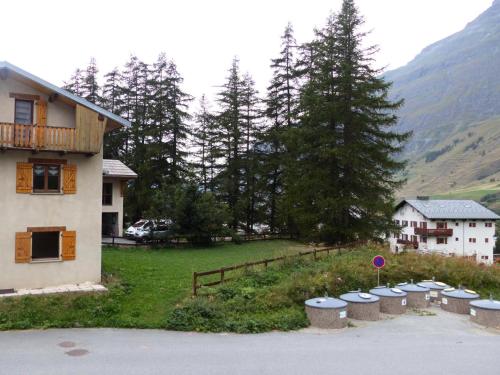 Une rangée de pots dans une cour à côté d'une maison dans l'établissement Résidence Le Clos Vanoise - Appartement 3 pièces lumineux MAE-4551, à Bessans