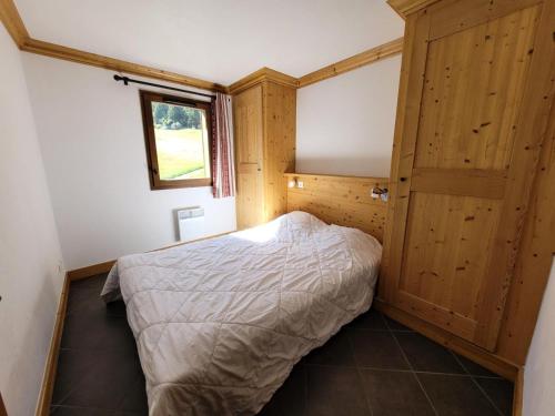 Schlafzimmer mit einem Bett und einer Holztür in der Unterkunft Résidence Le Criterium - Résidence Le Critérium 3 Chalet D Appartement 3 MAE-4581 in Lanslebourg-Mont-Cenis
