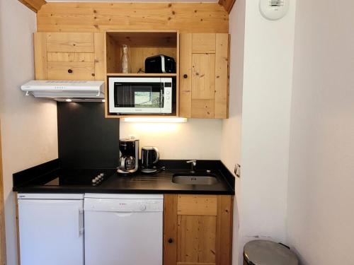 eine kleine Küche mit Spüle und Mikrowelle in der Unterkunft Résidence Le Criterium - Résidence Le Critérium 3 Chalet D Appartement 3 MAE-4581 in Lanslebourg-Mont-Cenis