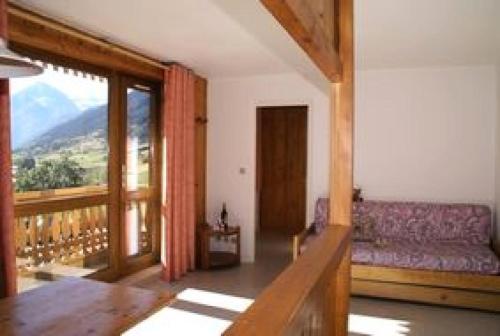 d'un salon avec un canapé et un balcon. dans l'établissement Résidence Parrachee - 2 Pièces pour 5 Personnes MAE-4641, à Val Cenis