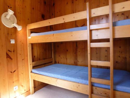 Ce lit superposé se trouve dans une chambre en bois. dans l'établissement Résidence Parrachee - 2 Pièces pour 5 Personnes MAE-4641, à Val Cenis