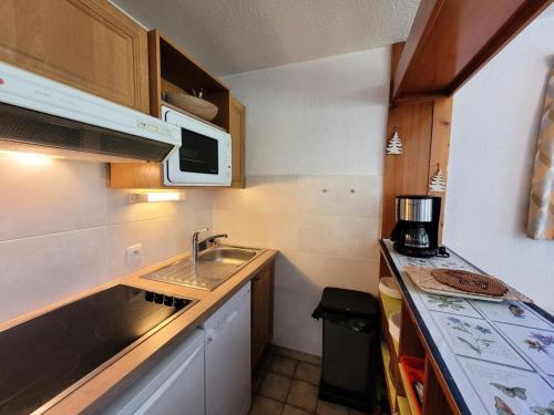 une petite cuisine avec un évier et un micro-ondes dans l'établissement Résidence Albaron - 3 Pièces pour 6 Personnes MAE-4701, à Bessans