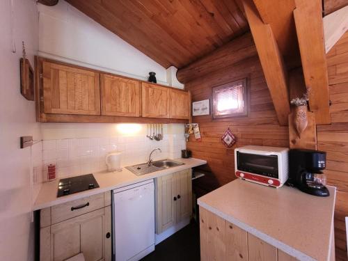une cuisine avec un évier et un micro-ondes sur un comptoir dans l'établissement Résidence Trolle-soldanelle - Studio pour 3 Personnes MAE-4691, à Bonneval-sur-Arc