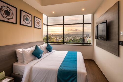 a bedroom with a large bed with a large window at The Lofts at Central Point in Bangalore