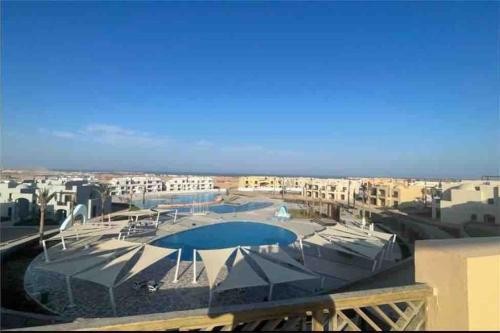 a view of a pool with umbrellas and buildings at 3 Bedrooms with roof in Makadi in Hurghada
