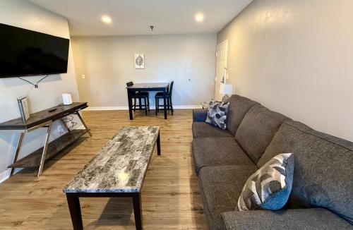 a living room with a couch and a table at Aksarben View Gem-Near UNO in Omaha