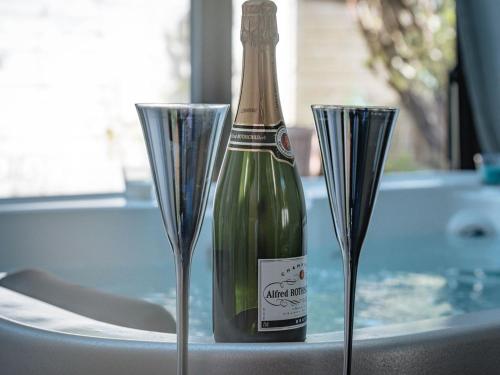 a bottle of champagne sitting next to two wine glasses at La Villa Côté Cour in Dinan