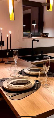 a table with two plates and two wine glasses at Haie Jad'Ô in Hamois