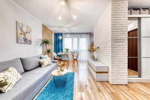 a living room with a gray couch and a table at Dwupokojowy apartament Fordon w okolicy Onkologii in Bydgoszcz