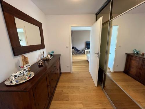 a bathroom with a wooden dresser and a mirror at Apartment in historical center with park view in Plzeň